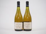 deux bouteilles de vin posées l'une à côté de l'autre sur une surface blanche