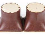 pair of brown leather boots with wooden heel pads on a white surface