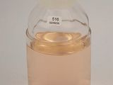 a bottle of liquid sitting on a table with a white background