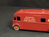 a red toy bus that is sitting on a black surface
