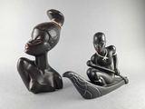 two figurines of a woman and a man sitting on a boat