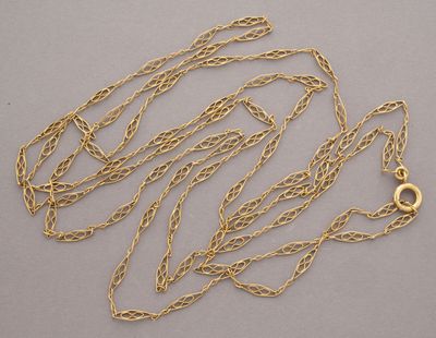 a close up of a gold chain with a clasp on a gray surface
