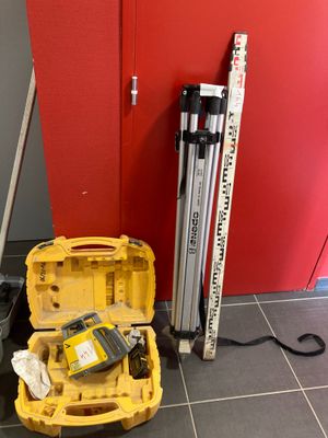 une boîte à outils jaune posée par terre, contenant des outils
