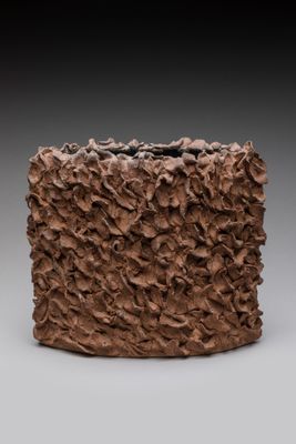 un gros plan d'un vase marron posé sur une surface grise