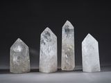a group of five clear quartz crystals on a black background