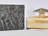 l'image d'un flacon de parfum posé à côté d'une boîte
