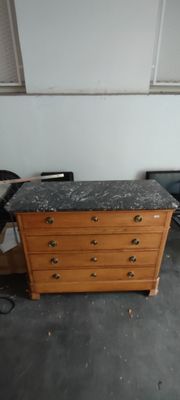 une commode avec un plateau en marbre, placée dans un coin de la pièce
