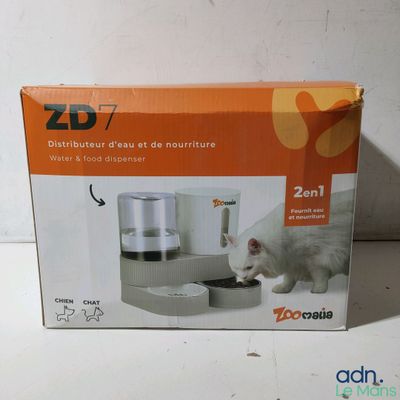 image encadrée représentant un chat en train de boire dans un distributeur de nourriture