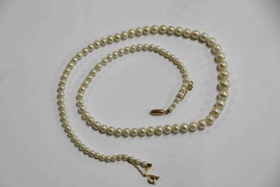 gros plan d'un collier de perles sur une surface blanche