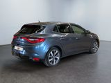 the rear end of a grey car in a white room
