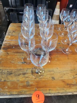 several empty wine glasses on a wooden table with a price tag