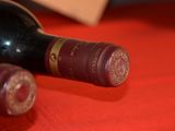 two bottles of wine sitting on a red cloth