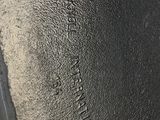 the bottom of a pair of black shoes that are on the ground