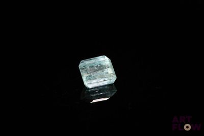 un gros plan sur un morceau de glace posé sur une surface noire