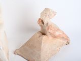a sculpture of a man sitting on a rock next to a bag