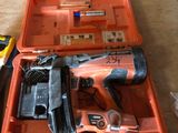une boîte à outils orange contenant des outils, posée sur une table