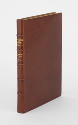 un livre en cuir marron avec une reliure dorée