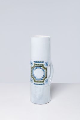 a close up of a white mug with a blue and green design on it