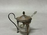 une théière en métal argenté contenant une cuillère et une cuillère