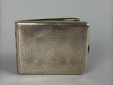 an image of a silver cigarette case sitting on top of a table