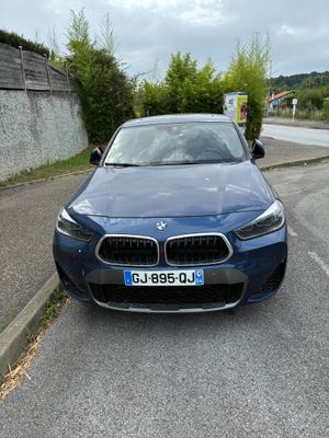 une BMW bleue garée sur le bord de la route