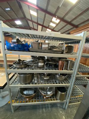 many pots and pans on the shelves in the kitchen