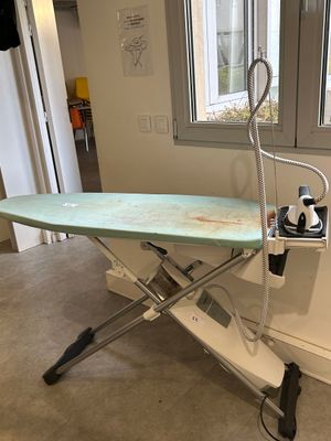 an ironing board sitting on top of an ironing board stand