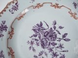 a plate with purple flowers on it sitting on a table