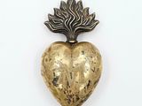 une broche en or en forme de cœur ornée d'une feuille