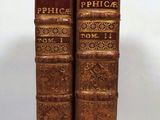 pair of antique books on a white surface with a white background