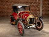 a red and gold car parked in front of a brick wall