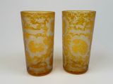 une paire de vases en verre jaunes et blancs posés sur une table blanche