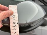 a person holding a measuring tape in front of a car