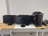 three computer monitors sitting on a desk next to each other