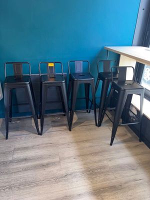 quatre tabourets et une table dans un coin de la pièce