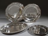 trois assiettes plaquées argent posées sur une table blanche, sur fond noir