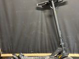 an electric scooter sitting on the floor in front of a black backdrop