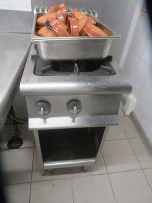 a stove with hotdogs on it in a kitchen