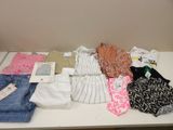 beaucoup de vêtements posés sur une table, avec une étiquette de prix