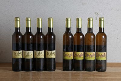 six bouteilles de vin sont alignées sur une table en bois