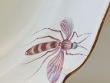 a white bowl with a dragonfly painted on it