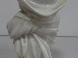 a white figurine with a hat on top of it
