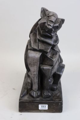 statue d'un chat assis sur un bloc de bois
