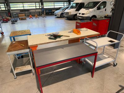 une table et des chaises dans un garage, avec une camionnette en arrière-plan