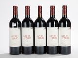 cinq bouteilles de vin sont alignées sur une surface blanche