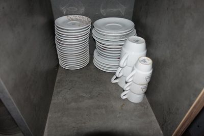 une pile d'assiettes et de tasses blanches dans une petite pièce