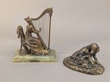 une statue représentant une femme jouant de la harpe, à côté d'une statue représentant un chien