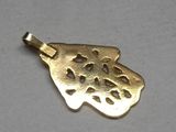 a close up of a gold plated pendant on a white surface