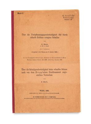 an old book with a red cover on a white background