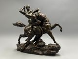 bronze statue of a man riding a horse on a rock